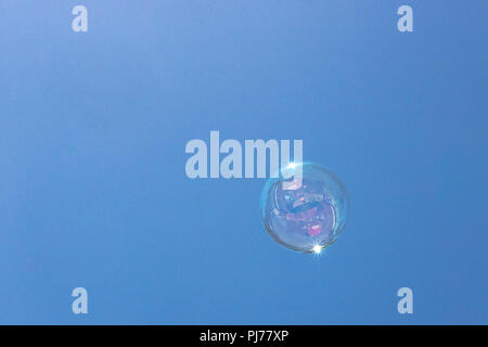 Nahaufnahme des einzigen Blase schwebend im Hintergrund des blauen Himmels mit Reflexionen in Bubble Stockfoto