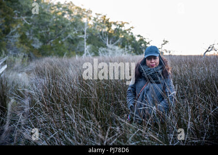 Frau, die in hohen schilfgras Stockfoto