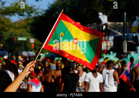 Eine Person, die Wellen eine Flagge Grenada an der West Indian Day Parade in Brooklyn Stockfoto