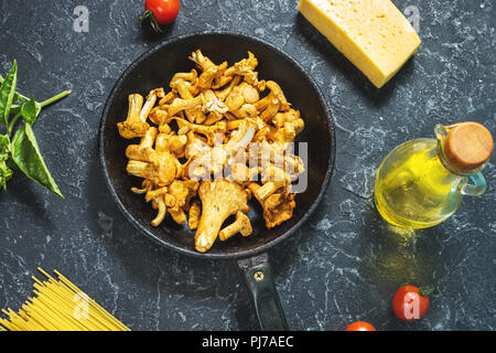 Teigwaren und Pfifferlingen Pilz auf dunklem Stein Hintergrund. Ansicht von oben. Stockfoto