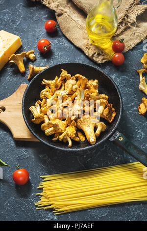 Teigwaren und Pfifferlingen Pilz auf dunklem Stein Hintergrund Stockfoto