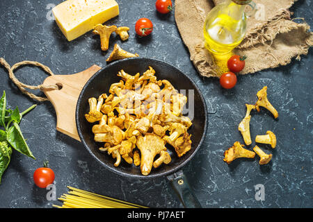 Teigwaren und Pfifferlingen Pilz auf dunklem Stein Hintergrund Stockfoto
