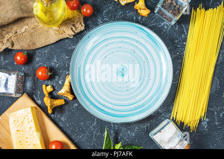 Teigwaren und Pfifferlingen Pilz auf dunklem Stein Hintergrund. Platz für Text Stockfoto