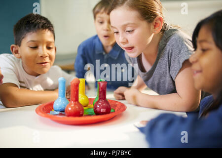 Neugierige Kinder beobachten multicolor Schaum in Bechern Stockfoto