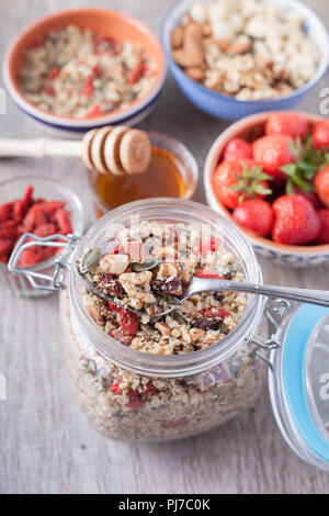 Getreide Hafer kostenlos Kostenlose paleo Müsli, rohe Nahrung: gemischte Nüsse, Samen, Goji Beeren, Chia, Honig, Erdbeeren, selektiven Fokus Stockfoto