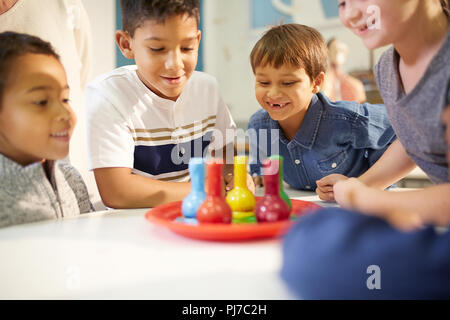 Neugierige Kinder beobachten Schaum in Bechern Stockfoto