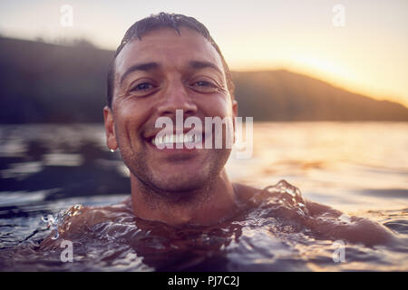 Close up Portrait lächelnd, sorglose Mann Schwimmen im Ozean Stockfoto