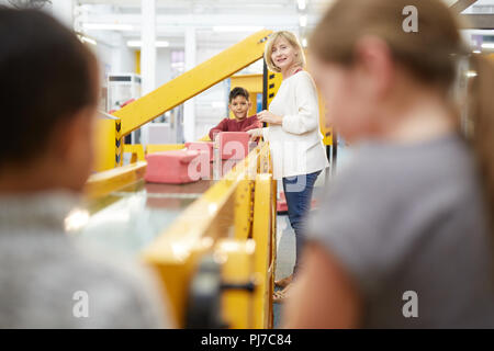 Lehrer und Schüler spielen auf der interaktiven Konstruktion weisen im Science Center Stockfoto