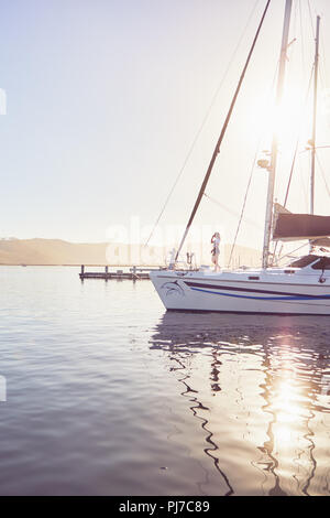 Frau, die an sonnigen Boot im Hafen Stockfoto