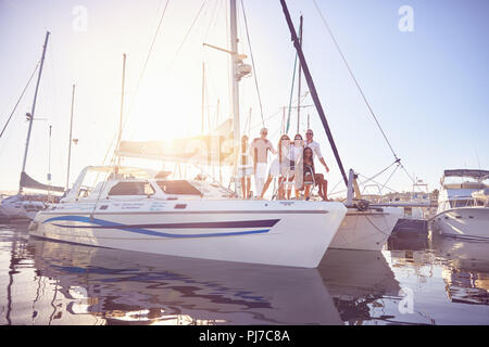 Portrait Freunde an sonnigen Catamaran im Hafen Stockfoto