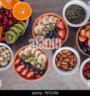 Smoothie mit Früchten und Beeren auf den grauen Holztisch, mit einer Vielzahl von Früchten und Nüssen herum, Ansicht von oben, Quadrat Stockfoto