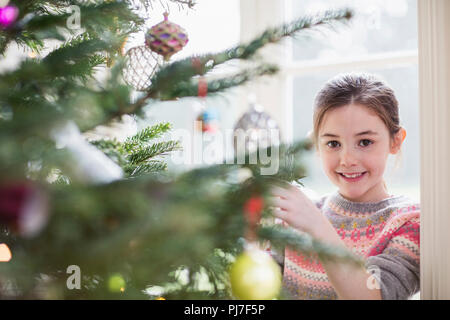 Portrait lächelnde Mädchen schmücken Weihnachtsbaum Stockfoto