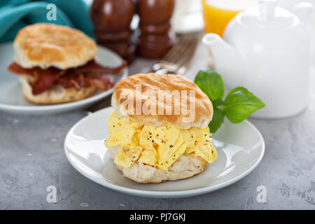 Frühstück Gebäck mit weichen Rühreier und Speck auf weiße Platte Stockfoto