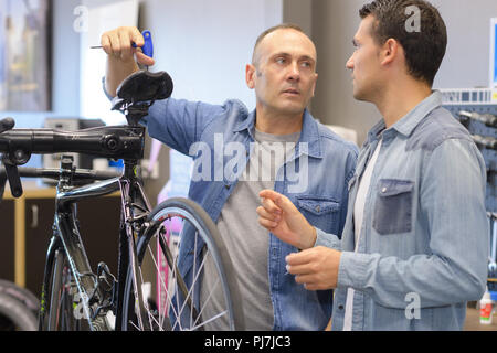 Man prüft Fahrrad vor dem Kauf im Sportgeschäft Stockfoto