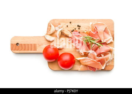 Italienische Prosciutto Crudo oder jamon mit Paprika, Tomaten, Knoblauch und Rosmarin auf Schneidebrett. Stockfoto