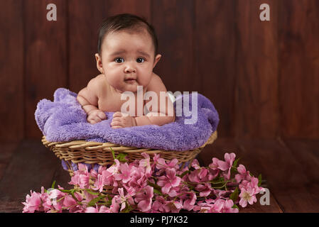 Lächeln glücklich niedlichen Baby Mädchen auf dunklem Hintergrund Stockfoto