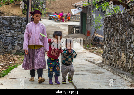 Ha Giang, Vietnam - am 18. März 2018: Mutter und Kinder zu Fuß auf einer Straße, die in der Lunge Cam Dorf in den Bergen im Norden von Vietnam Stockfoto