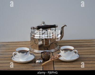 Kaffee bereit, in einem alten Wasserkocher mit Holzgriff, Kaffee Tassen, teeei und Süßigkeiten Stockfoto