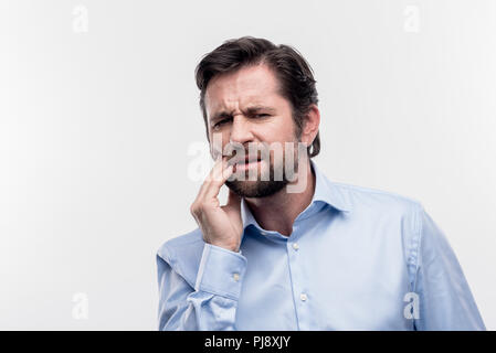 Reife Bärtige dunkelhaarige Geschäftsmann Zahnschmerzen leiden. Stockfoto