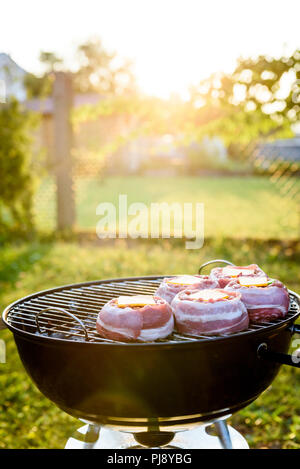 Die hausgemachte Bier kann Bacon Burger am Grill zubereitet. Vorbereitung gefüllte Pastetchen, in Speck umwickelt und Grillen auf indirekte Hitze in der Natur an der Bac Stockfoto