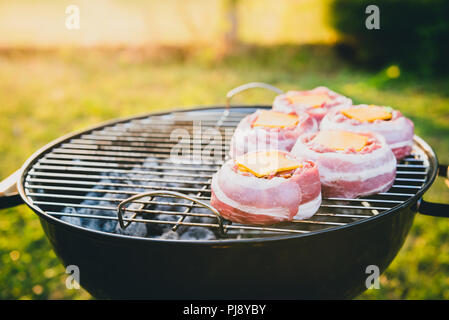 Die hausgemachte Bier kann Bacon Burger am Grill zubereitet. Vorbereitung gefüllte Pastetchen, in Speck umwickelt und Grillen auf indirekte Hitze in der Natur an der Bac Stockfoto