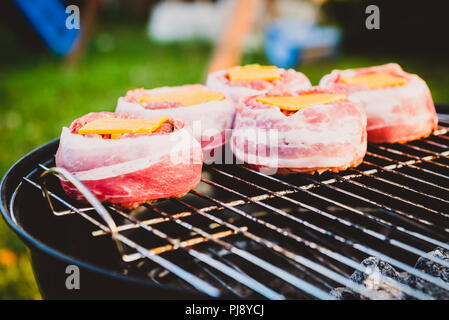 Die hausgemachte Bier kann Bacon Burger am Grill zubereitet. Vorbereitung gefüllte Pastetchen, in Speck umwickelt und Grillen auf indirekte Hitze in der Natur an der Bac Stockfoto