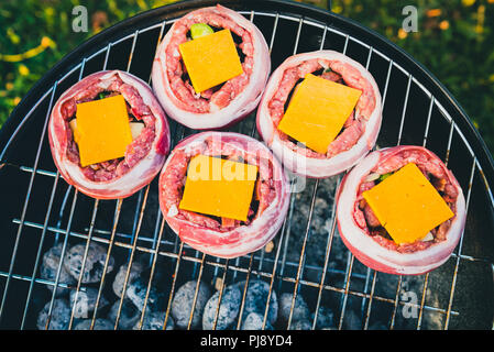 Die hausgemachte Bier kann Bacon Burger am Grill zubereitet. Vorbereitung gefüllte Pastetchen, in Speck umwickelt und Grillen auf indirekte Hitze in der Natur an der Bac Stockfoto