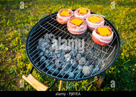 Die hausgemachte Bier kann Bacon Burger am Grill zubereitet. Vorbereitung gefüllte Pastetchen, in Speck umwickelt und Grillen auf indirekte Hitze in der Natur an der Bac Stockfoto