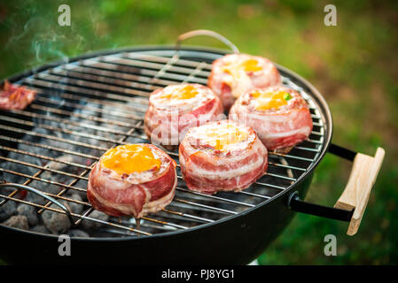 Die hausgemachte Bier kann Bacon Burger am Grill zubereitet. Vorbereitung gefüllte Pastetchen, in Speck umwickelt und Grillen auf indirekte Hitze in der Natur an der Bac Stockfoto