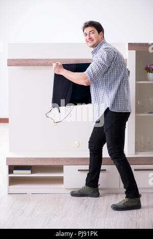 Mann, der versucht, defekte Fernseher zu reparieren Stockfoto