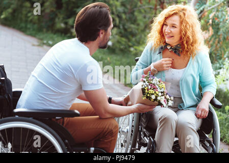 Überrascht arbeitsunfähig Dame Blumen von Freund Stockfoto