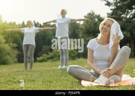 Gerne ältere Dame Erholung nach intensivem Training Stockfoto