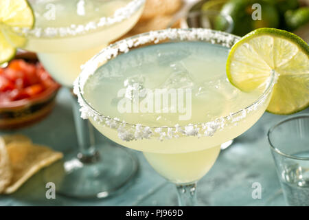 Lecker Tequila und Kalk margaritas auf einem Tisch im Freien mit Tortilla Chips und Pico de Gallo. Stockfoto