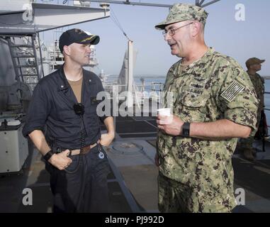 Marinestation Guantánamo Bay, Kuba (4. Juli 2018) - Hintere Adm. John C. Ring, Kommandeur der Joint Task Force Guantanamo, spricht mit Cmdr. Jeff Betz, Executive Officer von Whidbey Island-Class Dock Landung Schiff USS Gunston Hall (LSD 44), nachdem das Schiff an der Marinestation Guantánamo Bay für einen geplanten Hafen besuchen. Gunston Hall ist der US-Flotte von Aktionen im Rahmen der Unterstützung der Südsee 2018, das ist eine jährliche gemeinsame Bereitstellung in der US Southern Command Verantwortungsbereich, wo eine Aufgabe Gruppen eine Vielzahl von Übungen und multinationalen Austauschs Verhalten zu int verbessern bereitgestellt Stockfoto