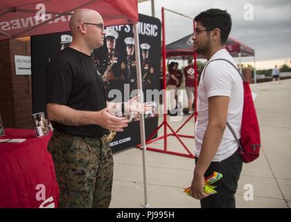 Gunnery Sergeant Matthew R. Phagan, die Musik Technische Assistentin mit 6 Marine Corps Bezirk, spricht mit einem Teilnehmer des Drum Corps International River Bluff High School in Lexington, South Carolina, Juli 07, 2018. Die Drum Corps International erstellt eine Bühne für die Marine Corps in Bildung, Wettbewerb zu beteiligen, und die Förderung der individuellen Entwicklung. Stockfoto