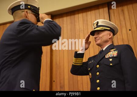 Coast Guard 13. Bezirk Master Chief Petty Officer Jason Wong, auf-kommenden command Master Chief, begrüßt der Adm. David Throop, Commander, nachdem Wong übernahm die Aufgaben der Bezirk command Master Chief während eines Change-of-watch Zeremonie in Seattle, 9. Juli 2018 statt. Eine Änderung der Watch ist ein zeitgesteuerter geehrt Festakt reich an naval Tradition, wo der gesamte Befehl die Übertragung der Verantwortung bezeugen können. Us-Küstenwache Stockfoto