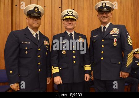 Coast Guard 13. Bezirk Master Petty Officer Jason Wong, auf-kommenden command Master Chief, hintere Adm. David Throop, Commander, und der Master Chief Petty Officer Sean McPhilamy, die Ausrückenden command Master Chief, nehmen Sie an von Change-of-watch Zeremonie in Seattle, 9. Juli 2018 statt. Während der Zeremonie Throop Vorsitz über Wong's Relief von McPhillamy. Us-Küstenwache Stockfoto