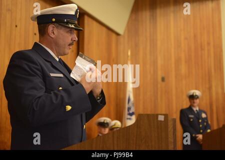 Master Chief Petty Officer Timothy Bart, die Ausrückenden Reserve Command Master Chief, Coast Guard 13. Bezirk, zeigt die Notizen für die Rede an die Masse während eine änderung - von - watch Zeremonie in Seattle, 9. Juli 2018 statt. Seine Geste war die Reaktion auf die beiden Vorredner, und nachdem er ihre Worte ergänzt er verfolgte mit seinem Display und stellte fest, dass seine Rede kurz sein würde. Us-Küstenwache Stockfoto