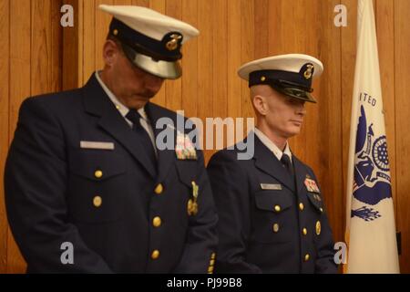 Coast Guard 13. Bezirk Master Chief Petty Officer Timothy Bart, die Ausrückenden Reserve Command Master Chief und der Master Chief Petty Officer Ryan Hooper, auf-kommenden Reserve Command Master Chief, ihren Kopf während eines Change-of-watch Zeremonie in Seattle, 9. Juli 2018 statt. Bart wird die Aufgabe als Reserve Command Master Chief für die Küstenwache den Pazifischen Raum in Alameda, Kalifornien, US Coast Guard übernehmen Stockfoto