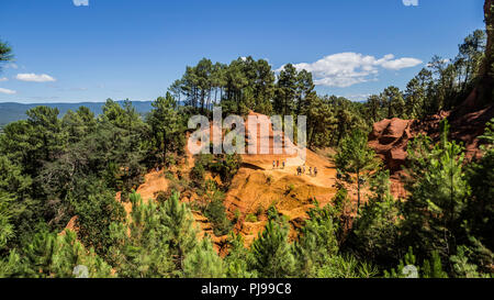 August 2018: Touristen verzaubert durch die rote Farbe des Sentier des Ocres. Eine alte Mine nun in Vergessenheit. August 2018 in Roussillon Stockfoto