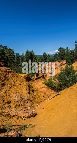 August 2018: Touristen verzaubert durch die rote Farbe des Sentier des Ocres. Eine alte Mine nun in Vergessenheit. August 2018 in Roussillon Stockfoto