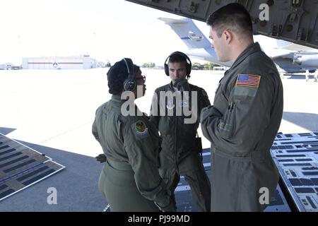 Us Air Force Airman First Class Sylvia Bannister (Links), Kapitän Aaron Ranking (Mitte) und Staff Sgt. Dereck Raxter diskutieren das Laden von medizinischen Geräten auf einem C-17 Globemaster III Flugzeuge, während auf der North Carolina Air National Guard Base, Charlotte Douglas International Airport, 9. Juli 2018. Dies ist die erste Mission für die Nord-carolina Air National Guard mit der C-17 und Transport von Geräten und Personal aus dem 156 Aeromedical Evacuation Squadron zur Wisconsin Air National Guard Base bei Volk Feld für eine Übung. Stockfoto