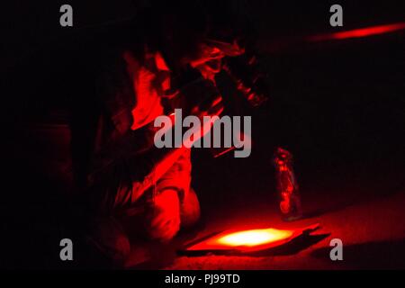 Unbekannten ORT, NAHER OSTEN - US Marine Corps Maj. Nicholas Hathaway, die Luft Naval Geschützfeuer Liaison Loslösung Offizier mit speziellen Zweck Marine Air-Ground Task Force, Krise Response-Central Befehl Kontakte die Ausübung Operations Center während einer taktischen Recovery von Flugzeugen und Personal (Trap) Übung Juli 9, 2018. Hathaway diente als Evaluator für Marines auf den Boden als sie die Übung durchgeführt. Stockfoto