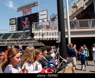 1. Sgt. Katie Blackwell und Staff Sgt. Ashley Meraz bereiten die amerikanische Flagge während der Minnesota 2018 Zwillinge Streitkräfte Anerkennung Tag anzuheben. Blackwell und Meraz sind beide Purple Heart Empfänger aus der Minnesota Army National Guard. Blackwell erhielt das Purple Heart, wenn Sie verwundet wurde, nachdem Ihr scout Fahrzeug schlug ein Improvised Explosive Device 29. Mai 2006, in Bagdad, Irak. Meraz wurde verwundet, nachdem ihr Fahrzeug über eine Druckplatte fuhr Improvised Explosive Device in der Nähe von Forward Operating Base Leatherneck in Afghanistan, 7. Oktober 2009. Ihr Fahrer, SPC. George Cauley, war töten Stockfoto