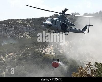 Marines mit Marine Light Attack Helicopter Squadron (HMLA) 267 und HMLA-169, Marine Aircraft Group (MAG) 39, 3. Marine Flugzeugflügel, Durchführung Wassereimer Tropfen über Feuerwehr zur Unterstützung der Löscharbeiten bei Marine Corps Base Camp Pendleton, Calif., Juli 6. Die "Pendleton Komplex", bestehend aus drei separaten Brände, brannte fast 2.000 Hektar. In allen sechs Flugzeugen vom 3. MAW durchgeführt fast 250 Wassertropfen über zwei separate Brände in 30 Stunden. Stockfoto