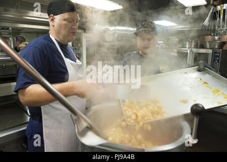 JOINT BASE Pearl Harbor - HICKAM, Hawaii (9. Juli 2018) Petty Officer 1st Class Allen Martin und Petty Officer 2. Klasse Michael Gabanyic bereiten das Mittagessen an Bord der USCGC Bertholf (WMSL 750) Juli 9, 2018, während in Pearl Harbor festgemacht, in der Unterstützung von Rimpac 2018. 25 Nationen, mehr als 46 Schiffe und 5 U-Boote, über 200 Flugzeuge und 25.000 Angestellte beteiligen sich an Rimpac vom 27. Juni bis 2. August in und um die Hawaiianische Insel und Südkalifornien. Die weltweit größte internationale maritime Übung RIMPAC bietet eine einzigartige Ausbildung während der Förderung und Erhaltung der Co Stockfoto