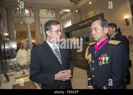 Tim Frank (links), Historiker, Arlington National Cemetery; bietet eine Führung durch die Gedenkstätte Amphitheater Anzeige Zimmer zu Gen. Koji Yamazaki (rechts), Chef des Stabes, Japan Masse Verteidigung-kraft; Auf dem Arlington National Cemetery, Arlington, Virginia, 10. Juli 2018. Yamazaki nahmen an eine Armee voller Ehrungen Wreath-Laying Zeremonie am Grab des Unbekannten Soldaten und traf sich mit Senior Leadership von Arlington National Cemetery als Teil von seinem Besuch. Stockfoto