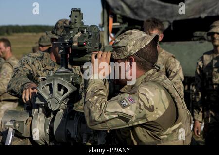 Eine britische Armee Soldat mit 1 Royal Horse artillery schaut durch ein 137 A2 Pantel Teleskop in Salisbury, England, 3. Juli 2018. Us-Marines mit Echo. Akku, 2. Bataillon, 10 Marine Regiment, 2nd Marine Division, leitete das Feuern Übungen auf dem M777 Haubitze während der Übung grüne Kanone 18. Grüne Kanone ist eine multinationale Übung mit US-Marines die Möglichkeit, Taktiken und Techniken sowie zu Exchange Projekt Letalität und Combat Power auf der ganzen Welt neben Partner Nationen. Stockfoto