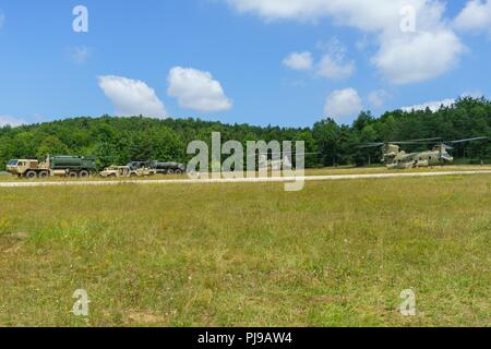 Der erdölversorgung Spezialisten der 404th Aviation Support Battalion, 4th Combat Aviation Brigade, 4 Infanterie Division, aus Fort Carson, Colo, tanken CH-47 Chinook Hubschrauber für Flugbesatzungen mit der 2. Allgemeine Unterstützung Aviation Battalion, 4th Aviation Regiment, 4 Kabine, auf einen Sprung vorwärts Bereich tanken Punkt (KASSENAERZTE) während eines Readiness Training übung in Hohenfels, Deutschland, 12. Juli 2018. Die Soldaten des Bataillons führen ihre erste Bereitschaft Übung seit seiner Ankunft im Land für Atlantic lösen, eine in den USA bemühen sich NATO-Verpflichtungen durch US-drehen-base zu erfüllen Stockfoto