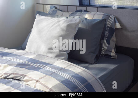 Weißen und Blauen Kissen auf dem Bett Karomuster Betten in modern eingerichtete Schlafzimmer Stockfoto